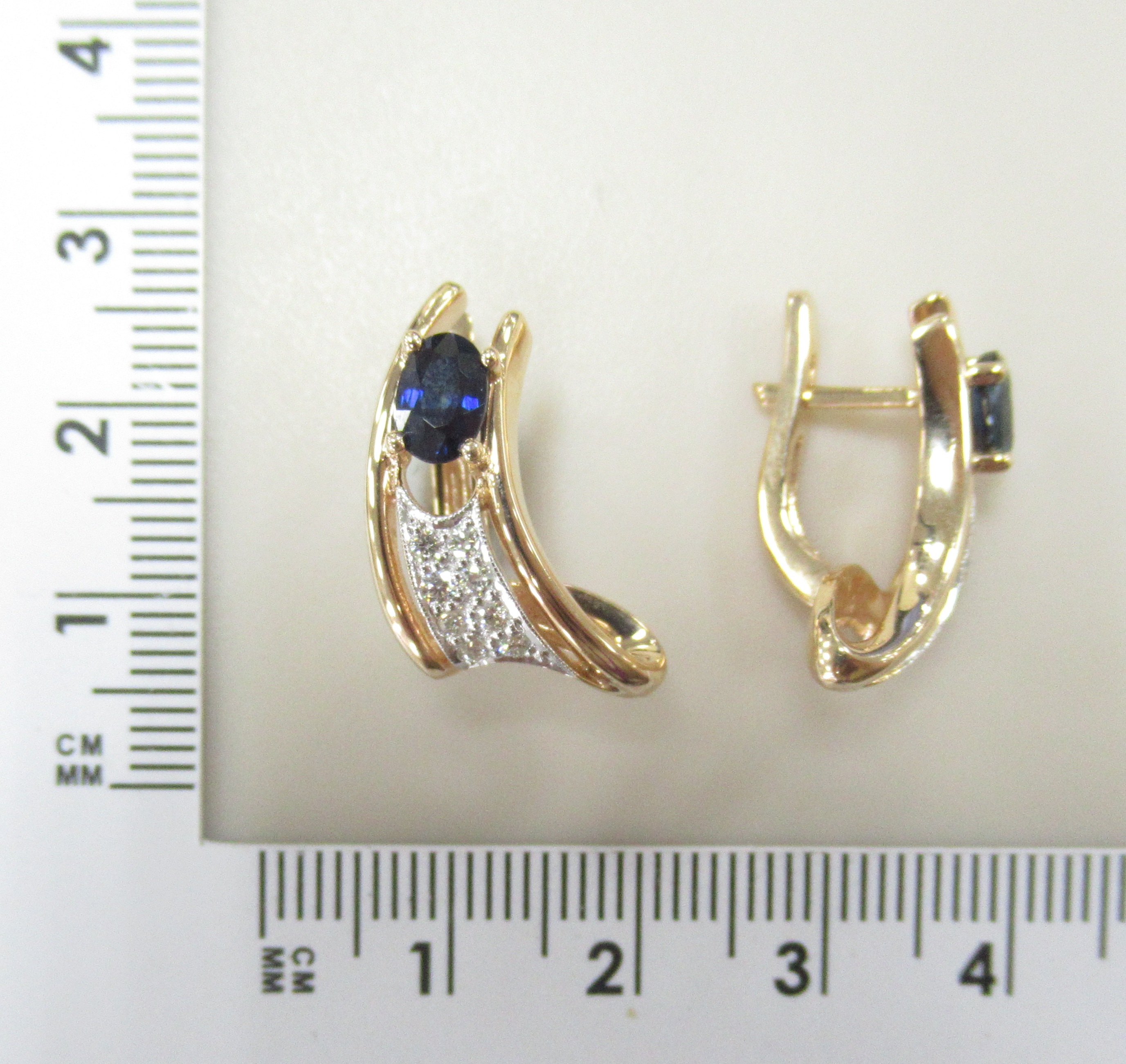 Золотые серьги 585 пробы; родий; вставки 16 Бр.Кр-57 0,27 4/5А; 2 Сапфир 1,43 2/2